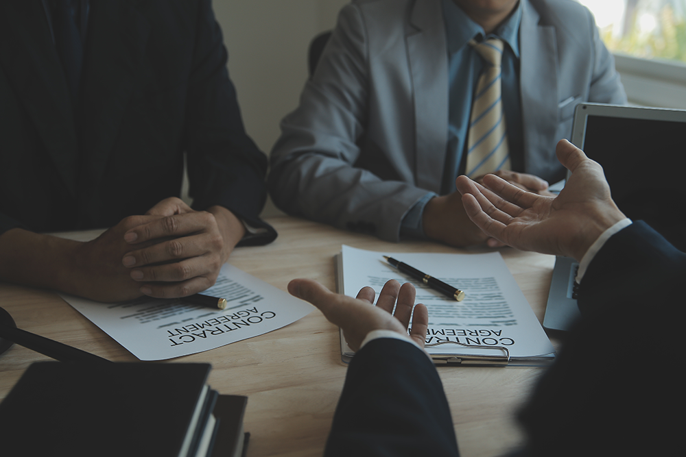 Image of four people sitting around a table holding a business meeting.